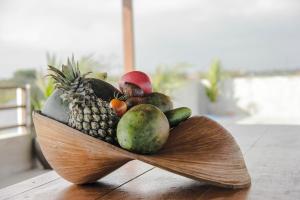 a wooden bowl filled with fruits and vegetables on a table at Govardan Home stay in Canggu