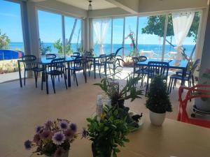a dining room with tables and chairs and the ocean at Cozy Khanom โคซี่ ขนอม in Ban Na Dan +62 photos