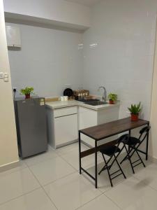 a kitchen with a table and a sink and a refrigerator at Arte Mont Kiara X Sonno in Kuala Lumpur