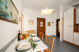 uma cozinha e sala de jantar com uma mesa branca e cadeiras em Casa Cabana - 200m From The Sea - Happy Rentals em Alassio