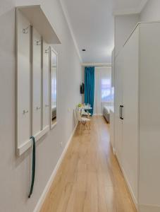 baño con armarios blancos y suelo de madera en Asaapart Vernyi Room 5, en Almaty