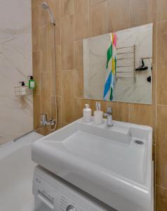 y baño con lavabo blanco y ducha. en Asaapart Vernyi Room 5, en Almaty
