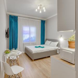 a bedroom with a bed and a table with a chair at Asaapart Vernyi Room 5 in Almaty