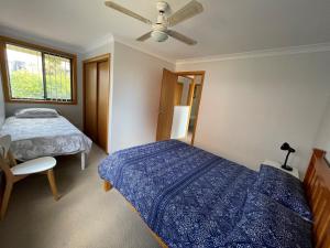 a bedroom with two beds and a ceiling fan at Seaview Townhouse 1 in South West Rocks