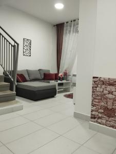 sala de estar con sofá y pared de piedra en Apartman Katy, en Sremska Mitrovica