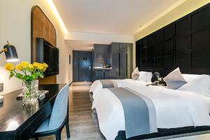 a hotel room with a large bed and a desk at Empathy Hotel - Guangzhou East Railway Station Tianhe Sports Center in Guangzhou