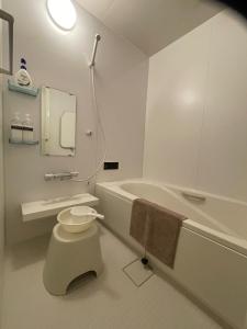 Un baño blanco con inodoro y bañera. en Petit Eturn Hakone, en Sengokuhara 41 fotos más