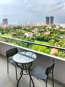 a table and two chairs on a balcony with a view at Grand Condo 7 in Phnom Penh