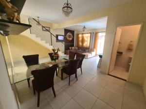 a dining room and living room with a table and chairs at Casa cinza in Aracaju