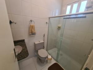 a bathroom with a toilet and a glass shower at Casa cinza in Aracaju
