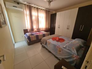 a bedroom with two beds in a room with a window at Casa cinza in Aracaju