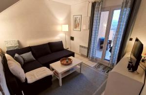 een woonkamer met een zwarte bank en een tafel bij Ferienhaus am Golf von Saint-Tropez in Cogolin