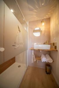 een badkamer met een glazen douche en een wastafel bij Les Voiles - Appart'hotel "Le Kornog" in Carnac