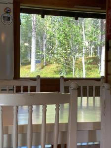 a window with a view of a forest from a crib at Jänkkärinne Cozy cabin Levi, Lapland in Kittilä