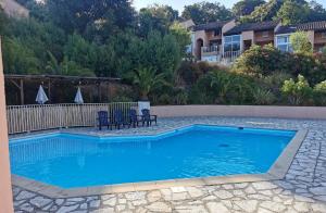 een zwembad met blauw water in een tuin bij Ferienhaus am Golf von Saint-Tropez in Cogolin
