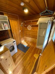 a kitchen with a washing machine in a wooden cabin at Jänkkärinne Cozy cabin Levi, Lapland in Kittilä