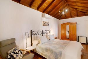 a bedroom with a bed and a chair at Casa Rural Arecida in Tijarafe