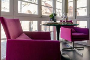 a dining room with purple chairs and a table at La Suite de la Catedral by Unique Rooms in Burgos