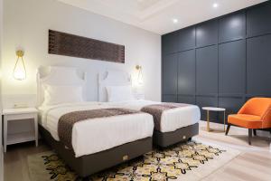 a bedroom with a large bed and an orange chair at The Difan Hotel in Jambi
