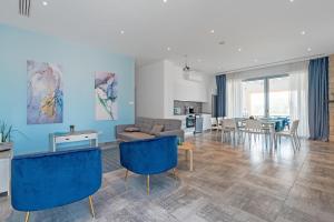 Blue Diamond Beach Villas في بافوس: غرفة معيشة مع كراسي زرقاء وأريكة