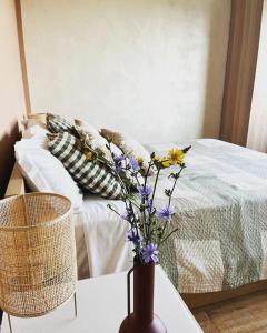 a vase with flowers on a table next to a bed at Mirabel in Chieti