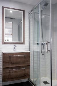 een badkamer met een glazen douche en een wastafel bij La Suite de la Catedral by Unique Rooms in Burgos