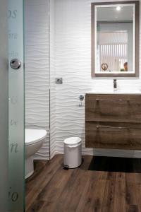 a bathroom with a sink and a toilet and a mirror at La Suite de la Catedral by Unique Rooms in Burgos