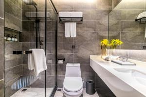 a bathroom with a toilet and a sink and a shower at Empathy Hotel - Guangzhou East Railway Station Tianhe Sports Center in Guangzhou