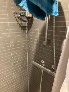y baño con ducha y toalla azul. en Værelse i lejlighed med udsigt og ro, en Aarhus