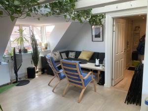 sala de estar con mesa, sillas y sofá en Værelse i lejlighed med udsigt og ro, en Aarhus