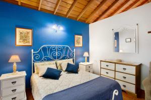 - une chambre bleue avec un lit et un mur bleu dans l'établissement La Roquina, à Tijarafe