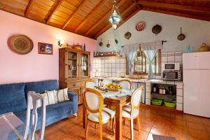 a kitchen and living room with a table and a blue couch at La Roquina in Tijarafe +15 photos