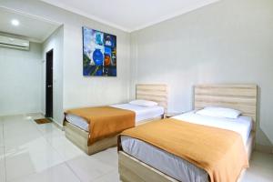 ein Schlafzimmer mit 2 Betten und einem Wandgemälde in der Unterkunft Palm Garden Kuta in Kuta