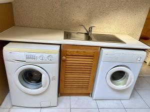 uma cozinha com duas máquinas de lavar roupa e um lavatório em Ocean View Townhouse em Santiago del Teide