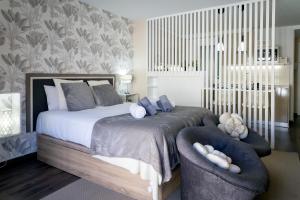 sypialnia z dużym łóżkiem z 2 krzesłami w obiekcie La Suite de la Catedral by Unique Rooms w mieście Burgos