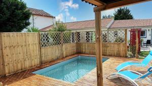 una piscina con 2 sillas y una valla en Le Clos des Passiflores - B&B, en Pons