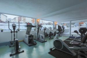 una palestra con diversi tapis roulant ed ellittiche di Hotel Alpin Superior a Saas-Fee