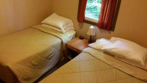 a room with two beds and a table with a window at K&G Lodge in Oswego