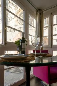 a table with two wine glasses and a window at La Suite de la Catedral by Unique Rooms in Burgos