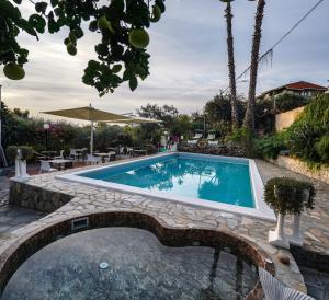 a swimming pool with a stone walkway around it at Hotel Bellavista in San Bartolomeo al Mare
