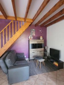 a living room with a couch and a staircase at Le Charme Normand in Norville