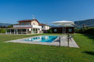 uma casa com piscina e guarda-sol em Villa Deluxe Giusti em Pescia