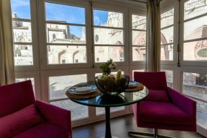 pokój ze stołem i dwoma krzesłami oraz oknem w obiekcie La Suite de la Catedral by Unique Rooms w mieście Burgos