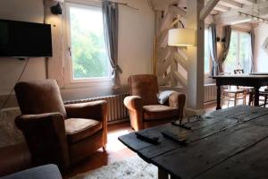 a living room with a wooden table and chairs at Maison à colombages près de Deauville, Trouville in Formentin
