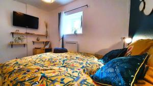 - une chambre avec un lit et une couette colorée dans l'établissement Le Georges, à Aiguilhe