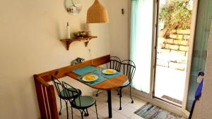 een tafel en stoelen in een keuken met een raam bij Ferienhaus am Golf von Saint-Tropez in Cogolin