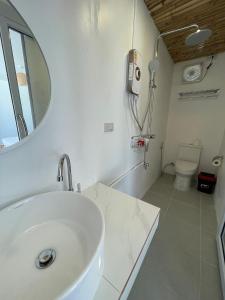 a bathroom with a sink and a mirror and a toilet at Nice Sea Resort in Srithanu