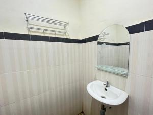 un baño con lavabo y espejo en RedDoorz @ Porodisa Homestay Palu, en Palu 12 fotos más