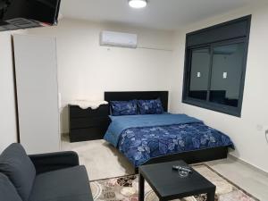 una camera con letto, divano e finestra di Durrat Al Israa a Umm el ‘Amad