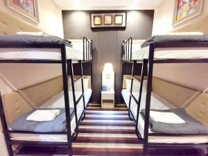 two bunk beds in a room with a hallway at Capital O 75451 Podstel Hostel Bangkok in Bangkok